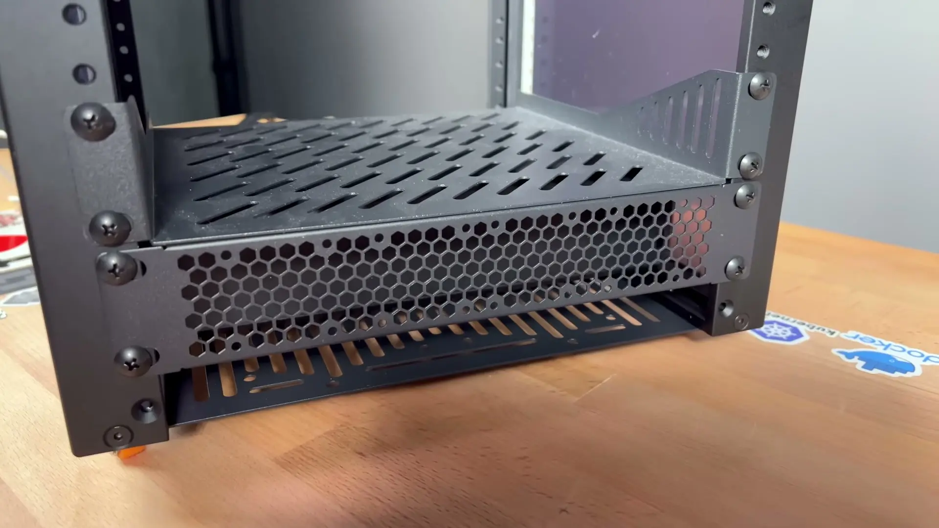 Vented 1U blanking panel mounted below a perforated RackMate shelf